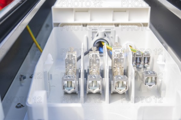 Interior view of a fuse box with various connections and cables, installation of a charging station