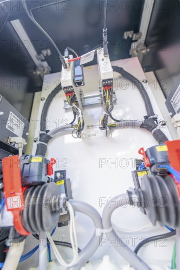 Close-up of the wiring and devices inside an electrical enclosure, assembly of a charging station