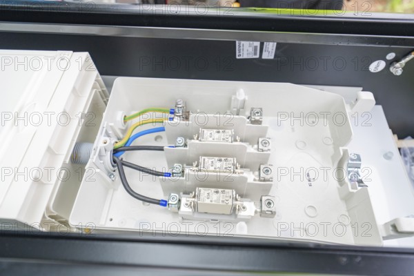 Interior view of a switch box with organised cables and fuses, installation of a charging station