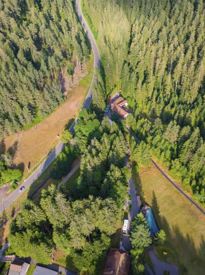 Aerial view of a winding road through a wooded area with neighbouring buildings, Retro Freizeitpark