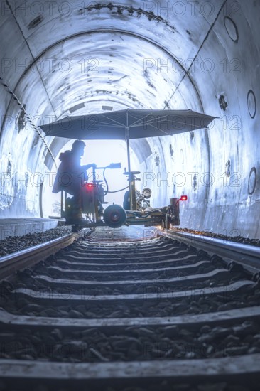 Machine used in the tunnel with umbrella-like construction on rails, surrounded by light and