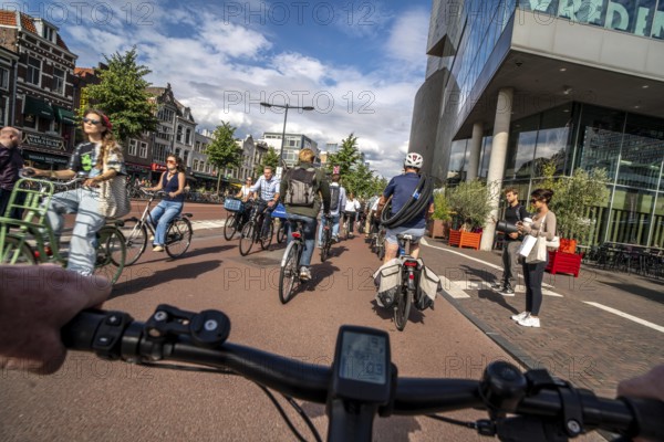 Ride your bike on the central cycle path on Lange Viestraat, Vredenburg, in the city centre of