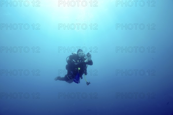 A diver floats alone during a safety stop in the blue depths of the Mediterranean Sea near Hyères,