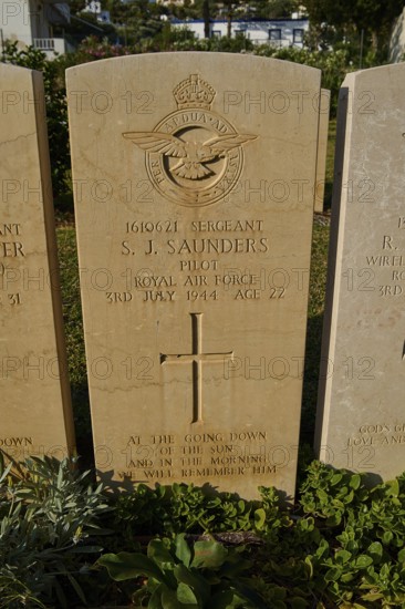 A gravestone with the emblem of the Royal Air Force, inscribed with personal and military