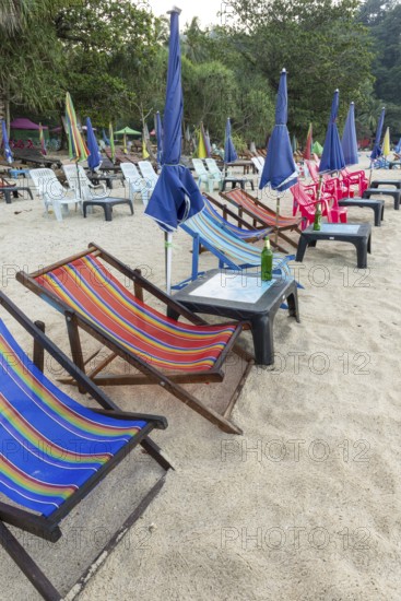 Abandoned deckchairs and parasol after sunset at Charlie Beach, Koh Mook Island, Andaman Sea,