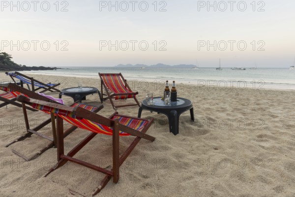 Abandoned deckchairs and parasol after sunset at Charlie Beach, Koh Mook Island, Andaman Sea,