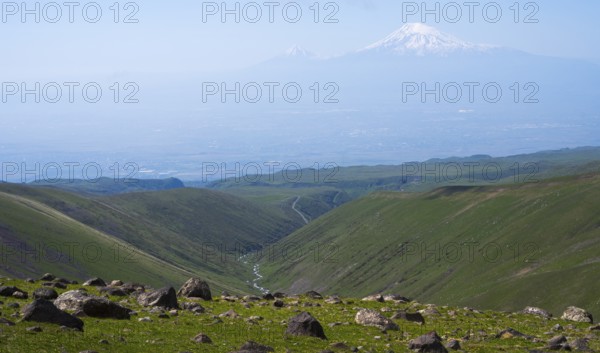 Extensive landscape with green valleys and snow-capped mountains on the horizon, view from Aragaz