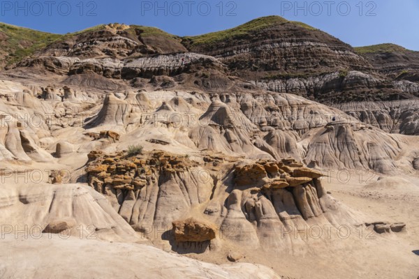 Sunlight illuminates the otherworldly landscape of the drumheller hoodoos, showcasing unique