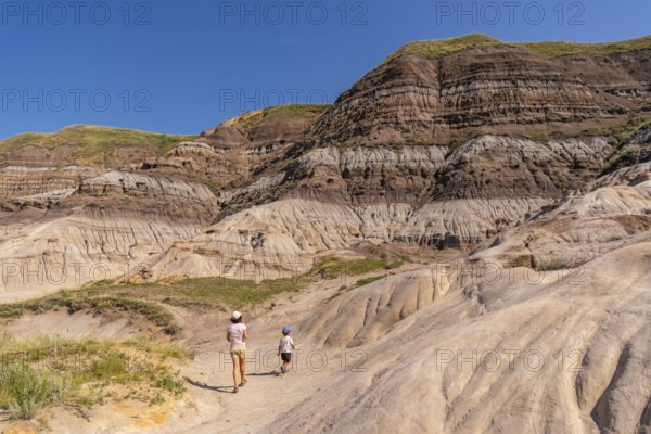 Tourists walking through horseshoe canyon under the bright summer sun, discovering the stunning