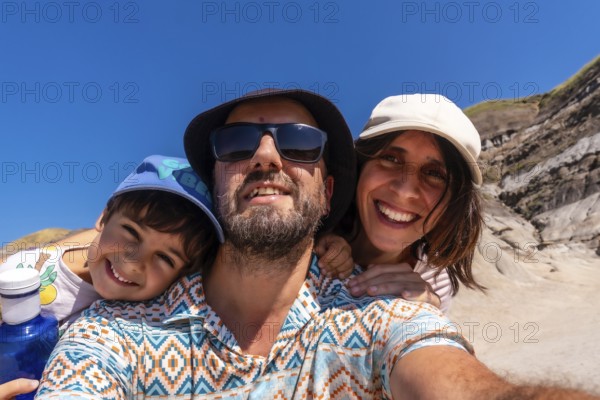 Happy family with a small child taking a selfie portrait with the arid landscape of drumheller,