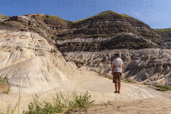 Tourist admiring the landscape of horseshoe canyon in drumheller, alberta, canada, enjoying the