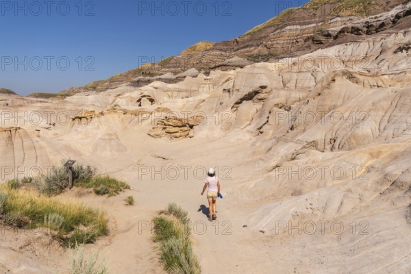 Female tourist walking on a trail in horseshoe canyon, a unique geological formation near