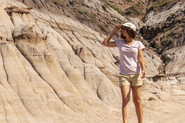Female tourist shielding her eyes from the sun while exploring the unique hoodoo rock formations in
