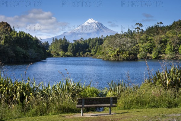 Park bench on Lake Mangamahoe with views of Mount Taranaki. Egmont National Park, Taranaki Region,