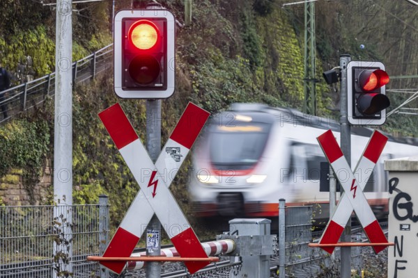 Rail crossing with regional train at Bad Wimpfen station. Flashing light, St. Andrew's Cross and