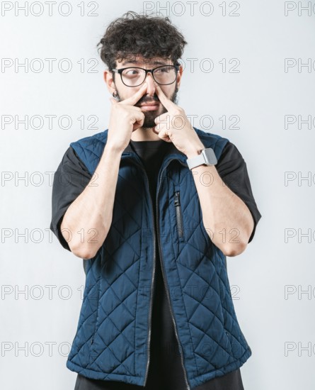 Young man with face of unpleasant odors, covering nose. Person covering nose because bad smells.