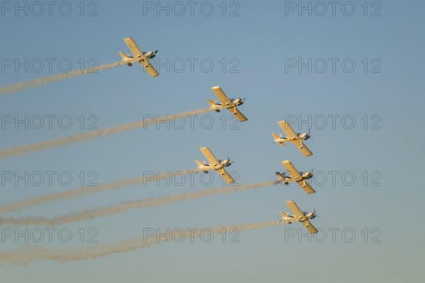 Stunt aerobatic planes performing stunts in blue sky with smoke trail. Concept of teamwork,