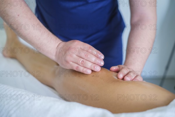 In a serene spa salon, a skilled therapist gives a soothing leg massage with oil, promoting
