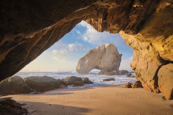 At Praia da Santa Cruz, Penedo do Guincho stands majestically as waves crash into the sandy beach