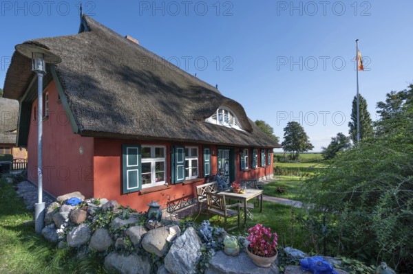 Private house with thatched roof, in front of a captain figure on a bench, Ahrenshoop, DarÃŸ,