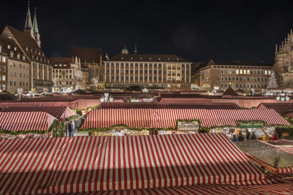 Christmas market illuminated in the evening with the Beautiful Fountain, Town Hall and towers of