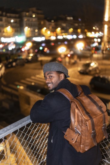 Young african man with a backpack and a cap. Smiling and looking at the camera. Standing on a