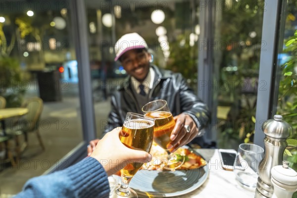 Diverse friends celebrating a successful night out, clinking beer glasses in a cheers gesture,