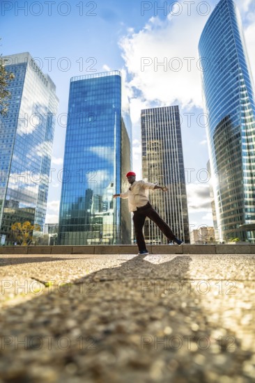 African american man maintaining balance on one leg with outstretched arms, performing street dance