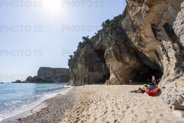 Sandy beach beach and steep cliffs with caves at Cala Luna, Golfo di Orosei, Baunei, Sardinia,
