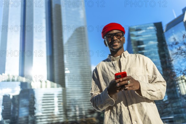 Young man smiling and checking content on his smartphone, linking to technology and modern
