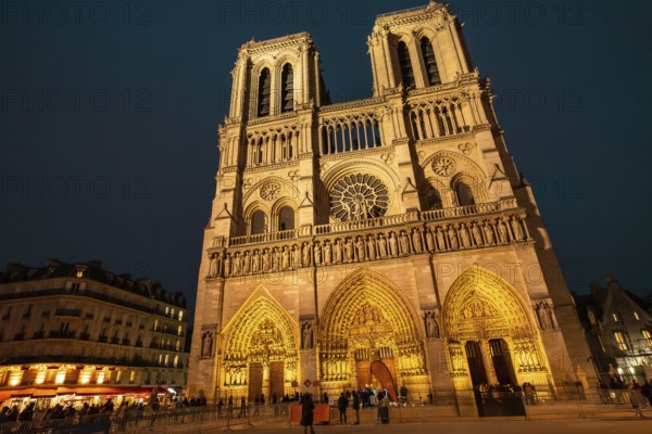 Notre dame de paris cathedral standing illuminated against the dark night sky, showcasing its