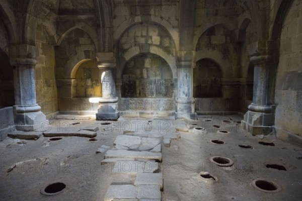 Arched stone interior with floor openings and atmospheric lighting through ancient arches, Haghpat