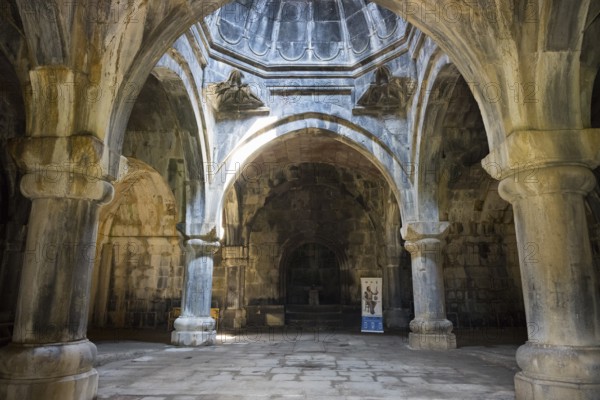 Historic interior with arched stone arches, through which rays of light create a mystical