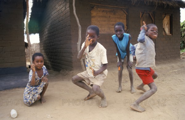 Children in front of a clay hut on the side of the road, girls, boys, Salima, Malawi, Africa, June