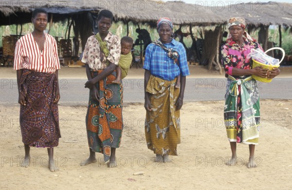 Local woman with a toddler pose for the camera in front of a street market, Salima, Malawi, Africa,