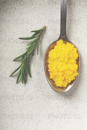 Yuzu caviar is pearly, on a spoon, top view, light background, no people