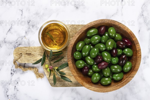 Chalkidiki olives, classic Greek green olives, in a bowl on a cutting board, top view, without