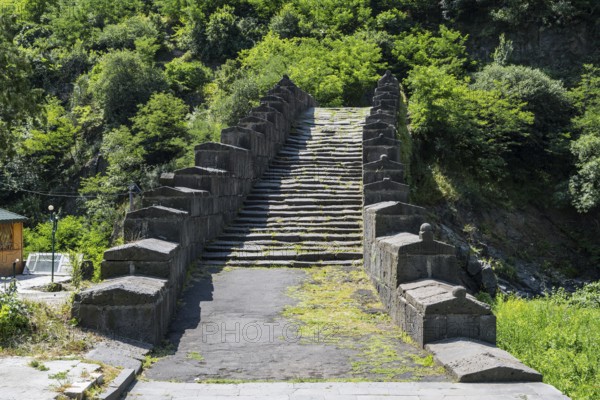 Historic stone staircase leads through a wooded landscape covered with moss, bridge, Sanahin bridge