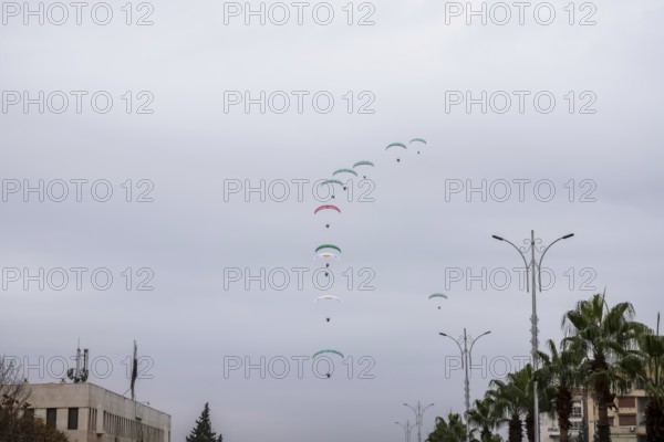 Damascus, Syria â€“ December 08, 2025: Paragliders display the Syrian flag during the first