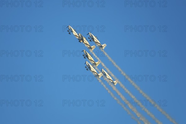 Stunt aerobatic planes performing stunts in blue sky with smoke trail. Concept of teamwork,