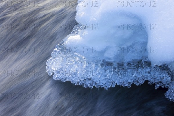 Ice formations and icicles formed by frost and freezing cold temperatures over running water of