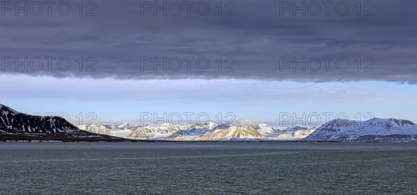 Snow covered mountains and glaciers debouching into Lilliehöökfjorden, fjord branch of Krossfjorden