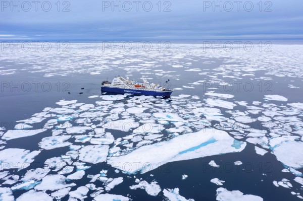 Aerial view over cruise ship Ocean Diamond from Iceland Pro Cruises sailing among drift ice / brash