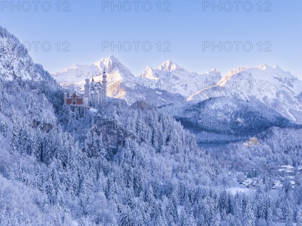 View of Neuschwanstein Castle in a vast, snowy mountain landscape. Impressive winter panorama,