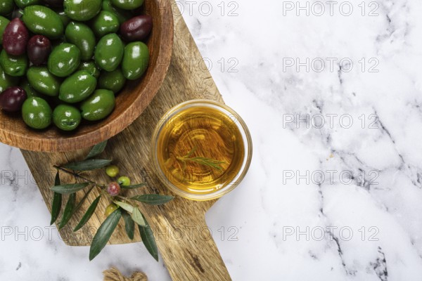 Chalkidiki olives, classic Greek green olives, in a bowl on a cutting board, top view, without