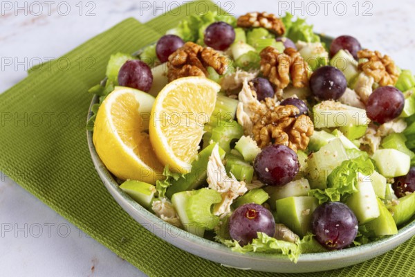 Fresh Waldorf salad, celery stalk with chicken, apple and walnuts, grapes, herbs, homemade, without