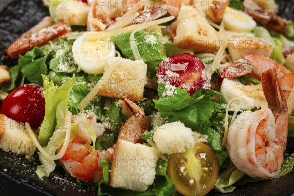 Caesar salad with tiger prawns, shrimp salad, lettuce leaves, quail eggs, cherry tomatoes, parmesan