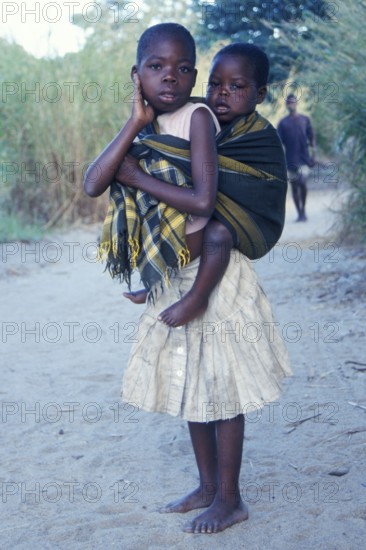 Girl carrying younger sibling at Kande Beach, Malawi, Africa, July 2000, vintage, retro, old,