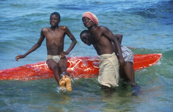 Teenager with surfboard in Lake Malawi, Kande, Malawi, Africa, July 2000, vintage, retro, old,
