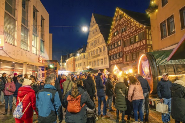 People enjoy the busy Christmas market in a half-timbered house town at night, Christmas market